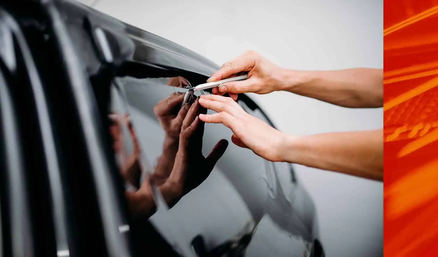 Wraptors Orlando, Vehicle Wraps, PPF & Tint Person uses a utility knife to trim window tint film on a car door, ensuring a precise fit during the installation process—a level of attention to detail you'd expect from Wraptors Orlando, the specialists in PPF and Orlando Florida Car Wraps. Orlando, FL